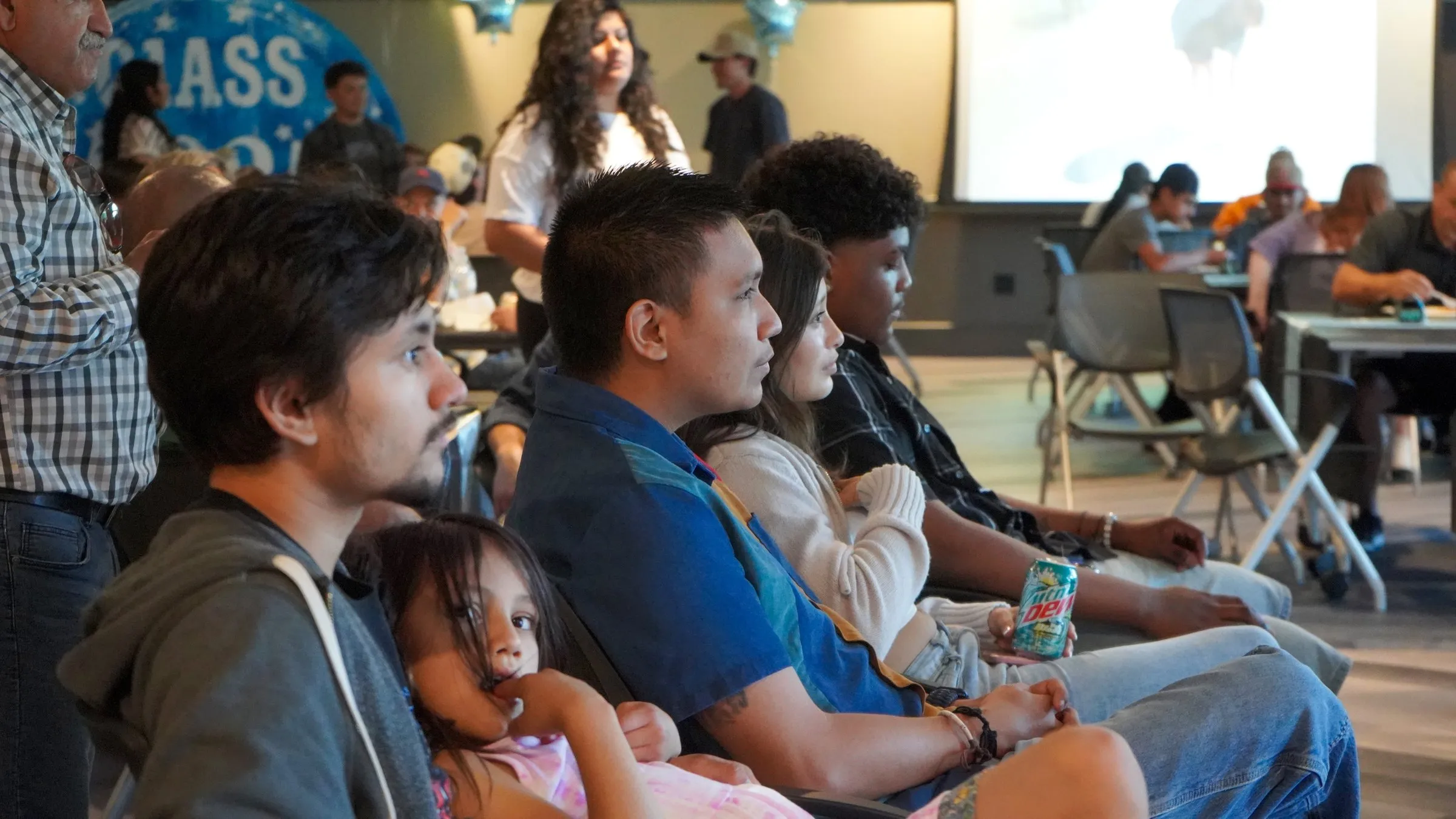 Family members watch a slideshow at a graduation party