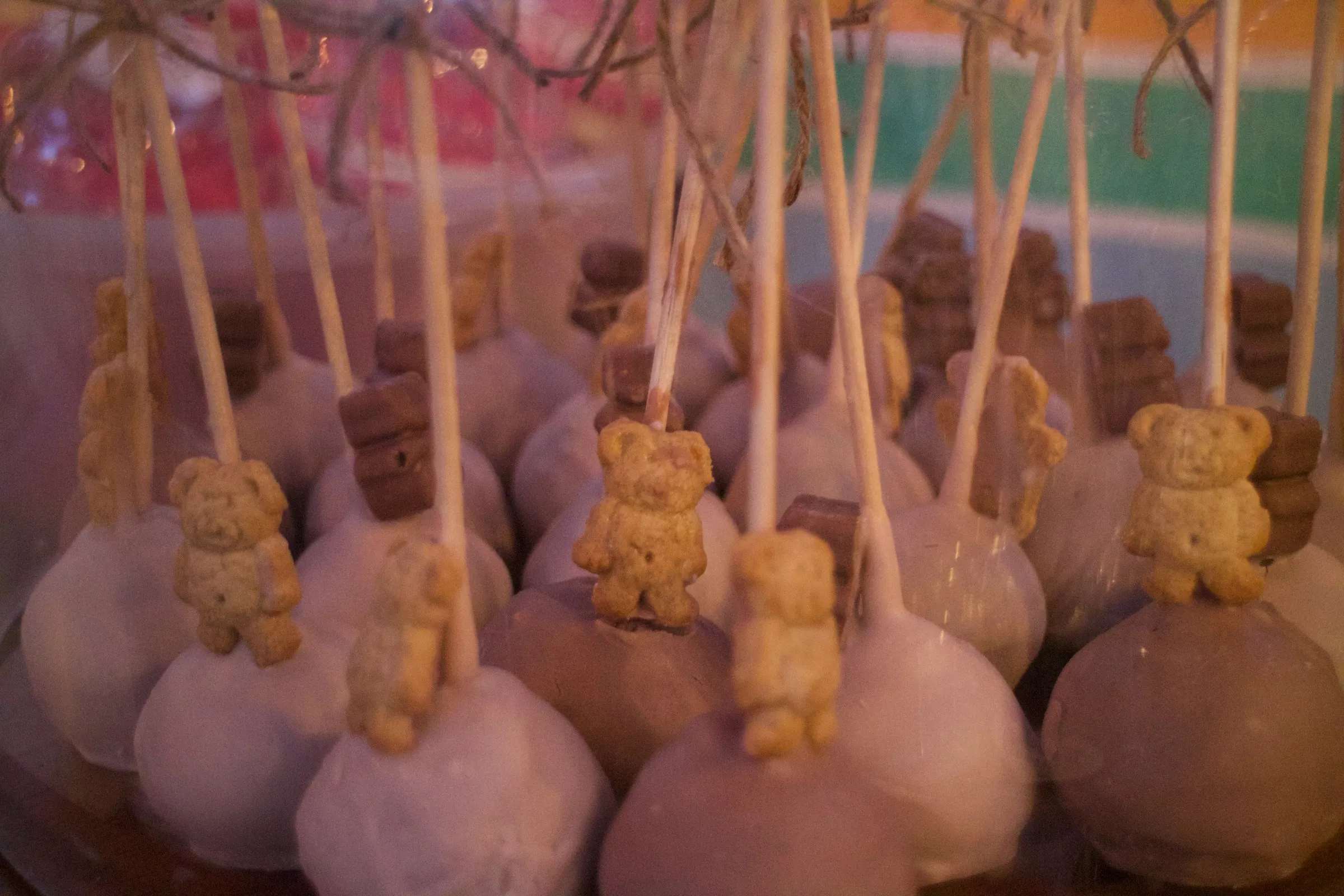 Rows of cake pops topped with tiny teddy bear cookies
